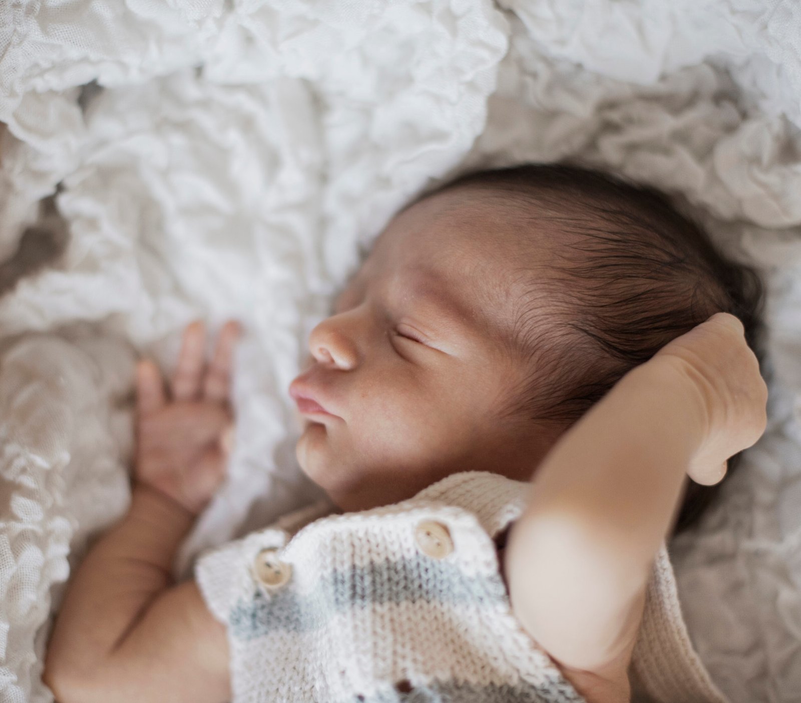 Portrait of a small baby taking a nap, showing a calm and serene expression while sleeping, representing the importance of rest in infant development