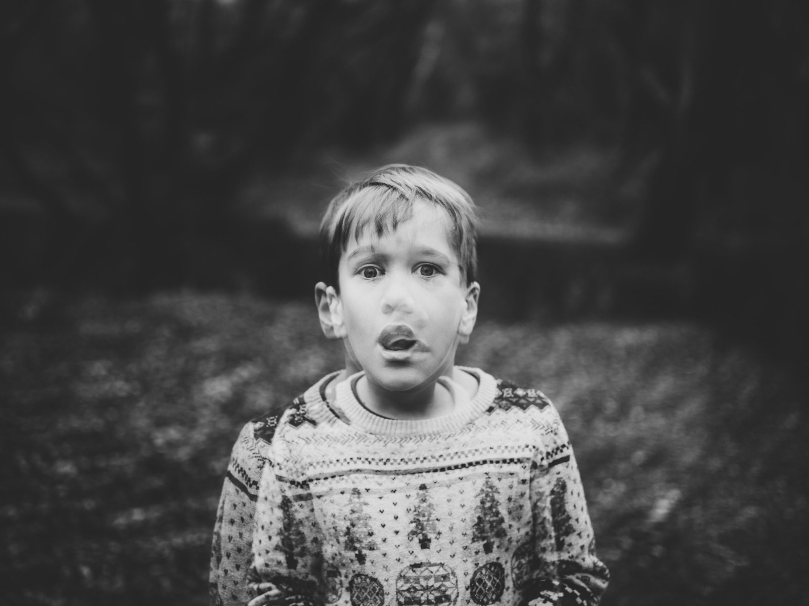 An anxious boy in a sweater looking down, representing fear and emotional struggles.