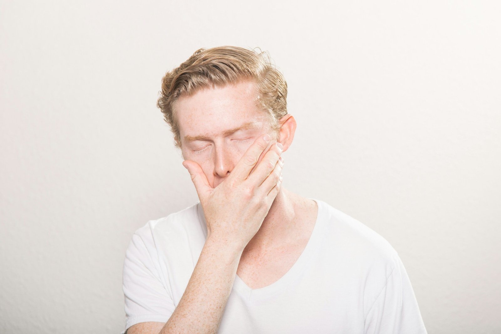 Man covering his mouth, representing emotional struggles linked to dysregulation disorder, a condition addressed by In the Cortex programs.