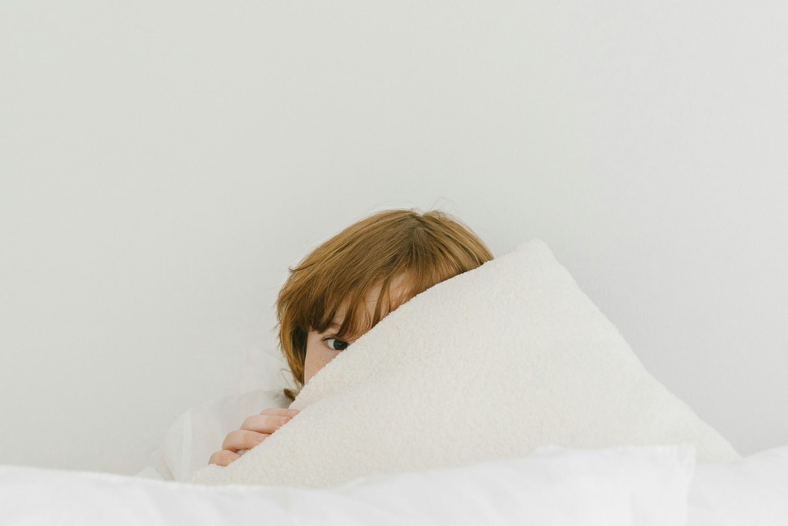 Boy hiding his face behind a towel