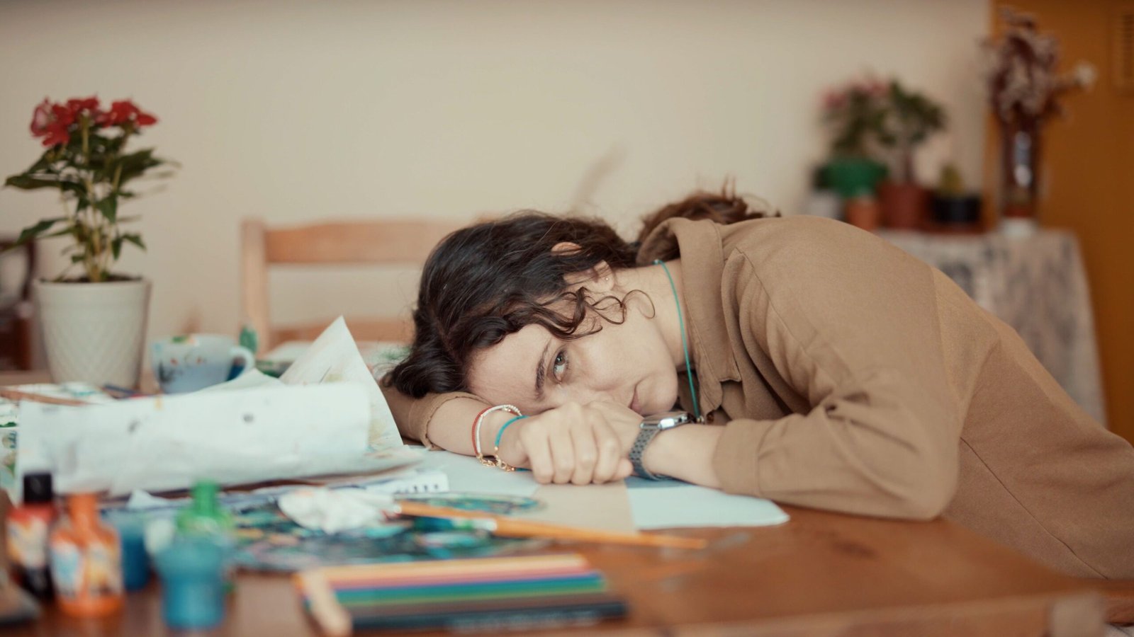 Woman lying head on her desk looking defeated